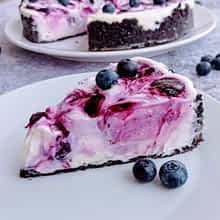 un trozo de cheesecake sin horno en un plato con arándanos