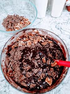 mezclando los trozos de chocolate en la masa de brownies