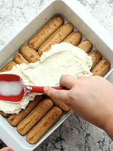 esparciando la primera capa de relleno encima de los ladyfingers