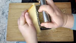 rallar queso para hacer la salsa de queso