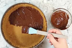 pintando el chocolate derretido encima de la base de galletas