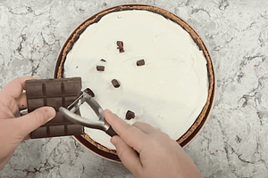 haciendo virutas de chocolate encima de la nata montada