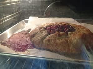 el galette de cerezas en el horno goteando su zumo en la bandeja
