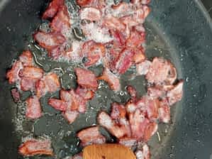 trozos de beicon cocinando en una sartén