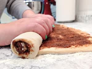 enrollando el rectángulo de masa rellenado de azúcar y canela