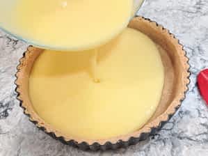 vertiendo el relleno de limón en la base de galletas