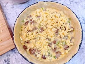 la masa cruda con la mitad de la salchicha y el queso