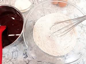 Asegúrate de que la mezcla de cacao este fría antes de añadirla. tazón grande con la masa de bizcocho de chocolate con los ingredientes secos mezclados