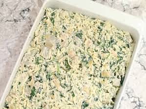 dip de espinacas y alcachofas en una cacerola listo para el horno