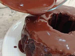 Dejar reposar el chocolate hasta que espese. Verterlo encima del bizcocho frío. vertiendo el glaseado ganache encima del bizcocho de chocolate horneado