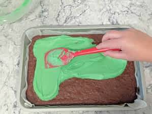 rociar glaseado de menta encima de brownies horneados