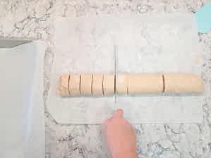 cortando el cilindro de rollos de canela y manzana