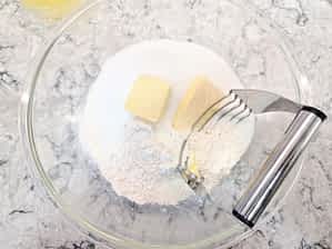 un bol grande con los ingredientes secos y la mantequilla en trozos