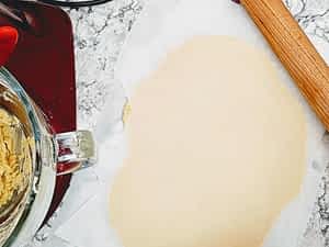la masa aplanada entre papeles de horno