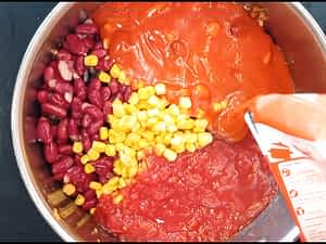 frijoles, maíz, y tomates en la olla