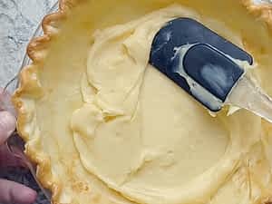 esparciendo la primera capa de crema pastelera en el pay