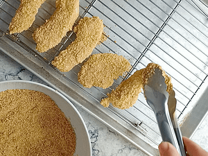 poniendo las tiras de pollo empanizadas en la rejilla