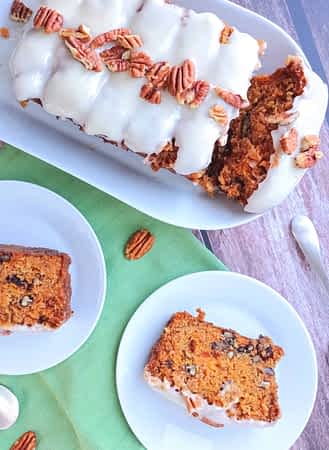 el bizcocho de zanahoria entero con unas rebanadas en platos