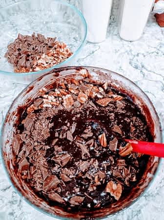 mezclando los trozos de chocolate en la masa de brownies