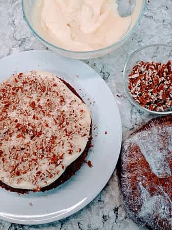 montando el glaseado y el bizcocho para hacer la tarta de zanahoria