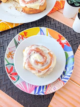 rollito de canela con glaseado de queso crema en un plato