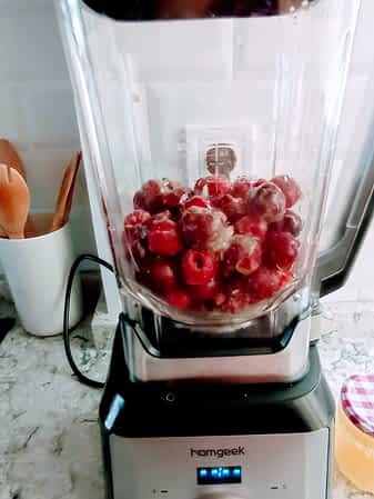 las cerezas congeladas están en la jarra de la licuadora