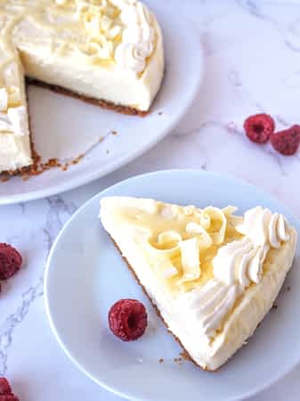 un trozo de tarta de queso sin horno al lado de la tarta entera