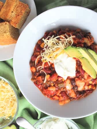 un bol de chili vegetariano en la mesa con toppings