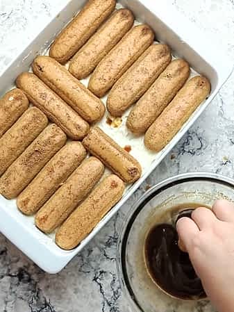 colocando la segunda capa de ladyfingers encima del relleno de marscapone