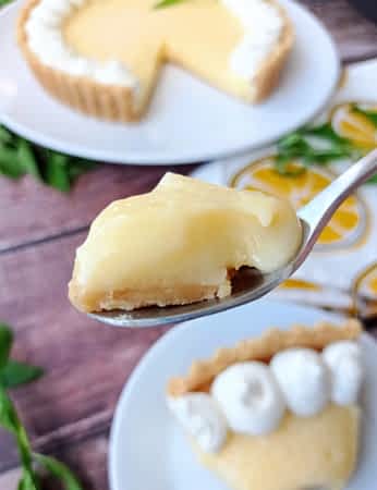 un bocado de tartaleta de limón en una cuchara