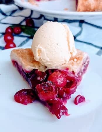 trozo de galette de cerezas en un plato con helado de vainilla encima