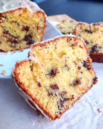 un trozo de bizcocho de naranja y chocolate en frente del bizcocho entero