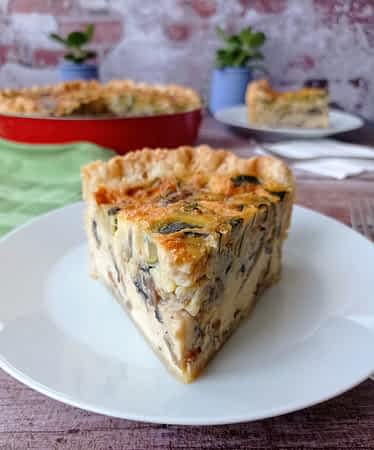 un trozo de quiche de calabacín y champiñones en un plato