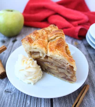 trozo de pay de manzana en un plato con nata montada