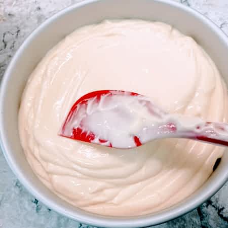 una espátula para alisar la masa de queso en el molde