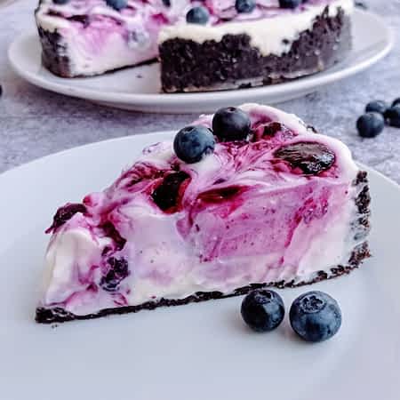 un trozo de cheesecake sin horno en un plato con arándanos