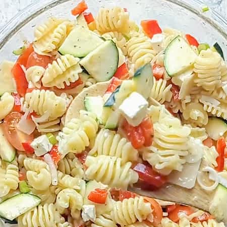 mezclando todos los ingredientes de la ensalada de espirales