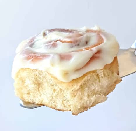 un cinnamon roll con glaseado Philadelphia de vista cerca