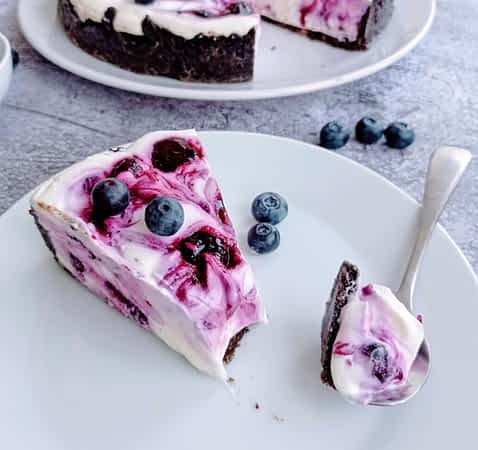 un trozo de cheesecake sin horno en un plato con un trocito al lado en una cuchara