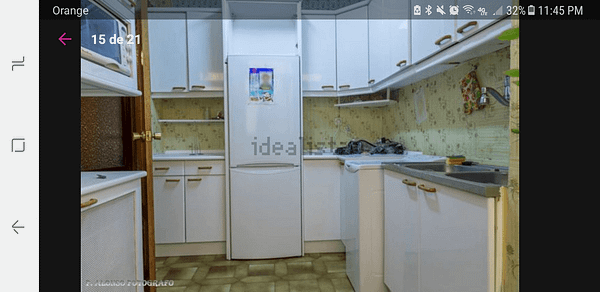 cocina antigua con nevera y armarios viejos