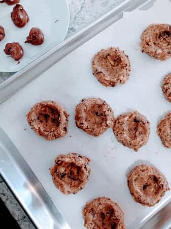 Proporciona la masa con una cuchara de helado, y usa los pulgares para hacerlas de forma bol. bolas de masa con hueco para poner nutella