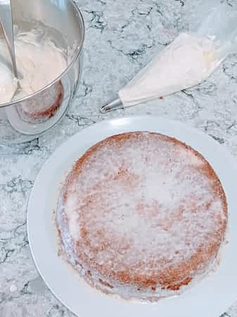 preparando la nata montada en una manga pastelera para decorar la tarta