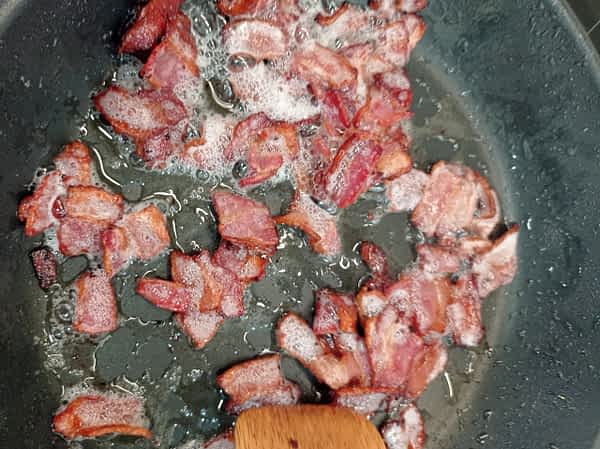 trozos de beicon cocinando en una sartén