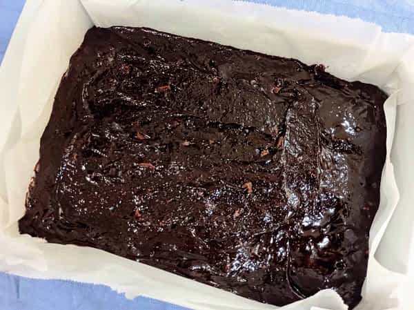 Aplanar la masa uniformemente en el molde. la masa cruda de los brownies en el molde rectangular listo para hornear