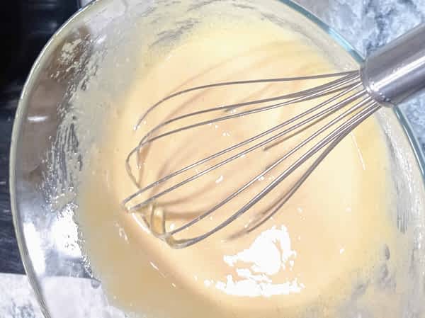 tazón con la mezcla de huevos más una mitad de la leche caliente