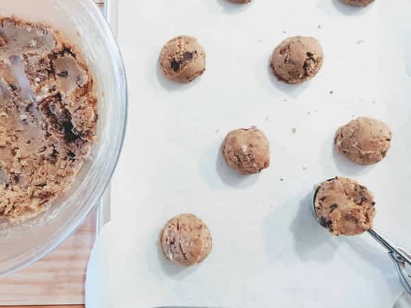 porcionando la masa de galletas de chocolate con una cuchara de helado
