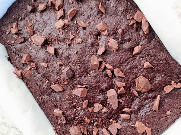 Opcionalmente esparcir trocitos de chocolate encima de los brownies calientes. los brownies recién hechos con trozos de chocolate encima