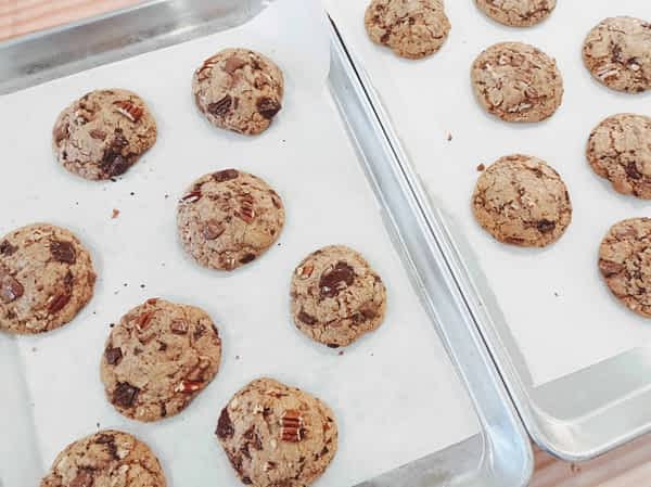 dos bandejas de galletas de chocolate recién sacadas del horno