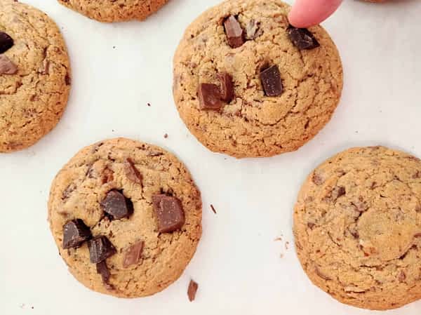 vista de cerca de poniendo chispas de chocolate encima de las galletas de chocolate americanas