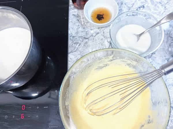 olla con leche y un tazón grande con los huevos y azúcar